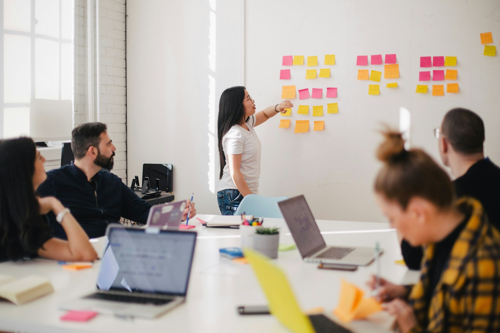 woman placing sticky notes on wall to group site opportunities